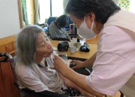 薬の飲まれているご利用者と介助するスタッフです