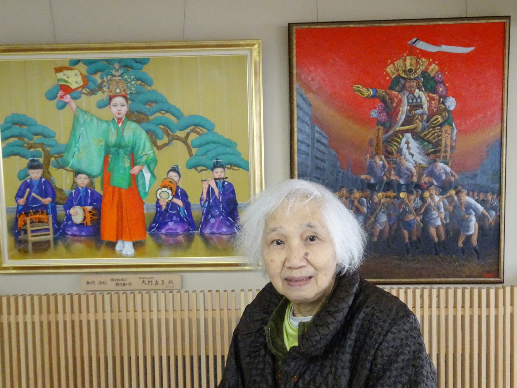 屋内休憩所にある山笠などの絵画の前で撮った写真