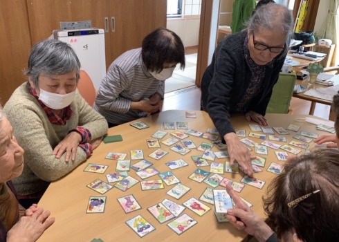 カルタで白熱する利用者さんたちの写真