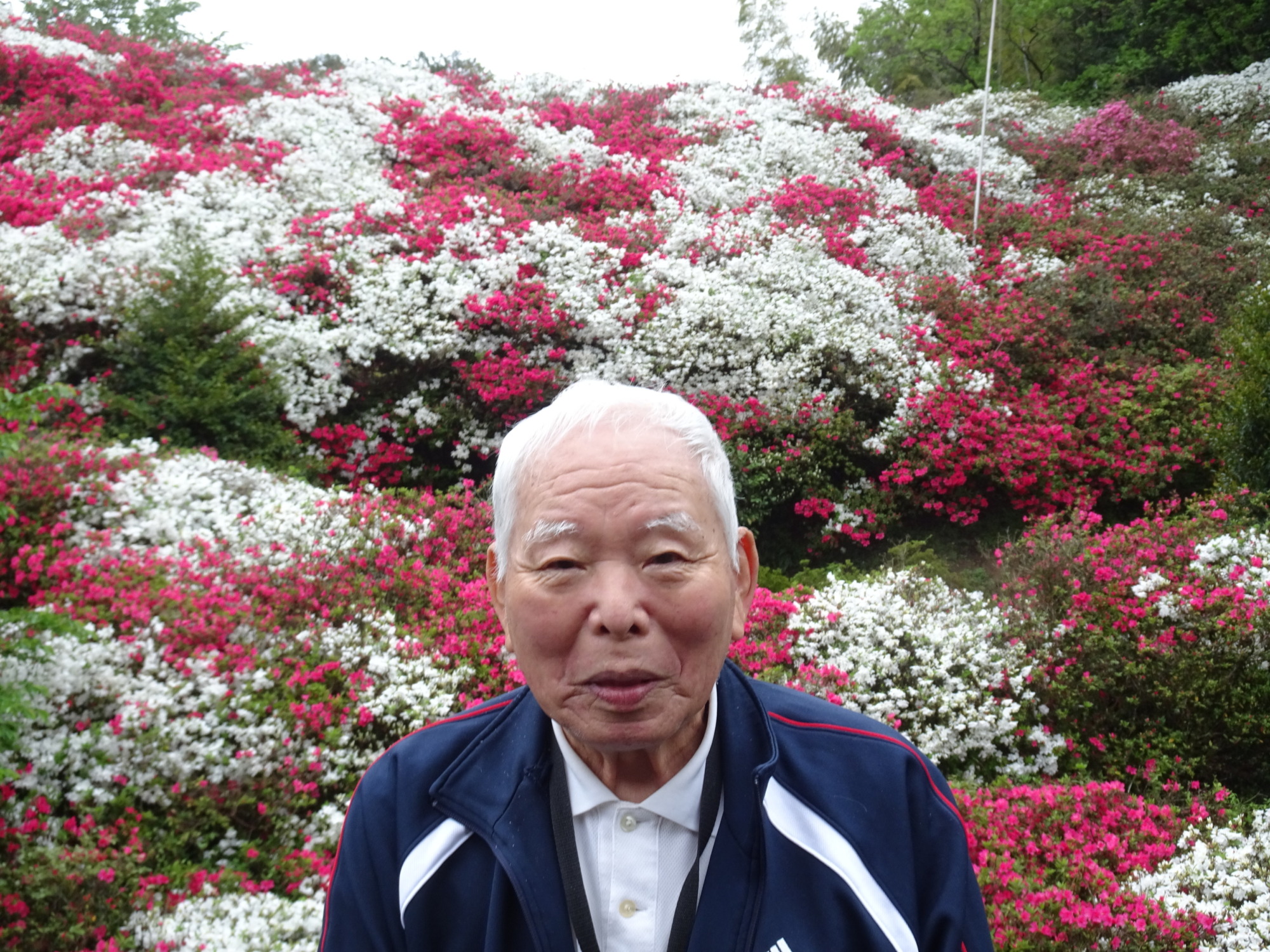 満開のつつじの前でとった利用者さんの写真