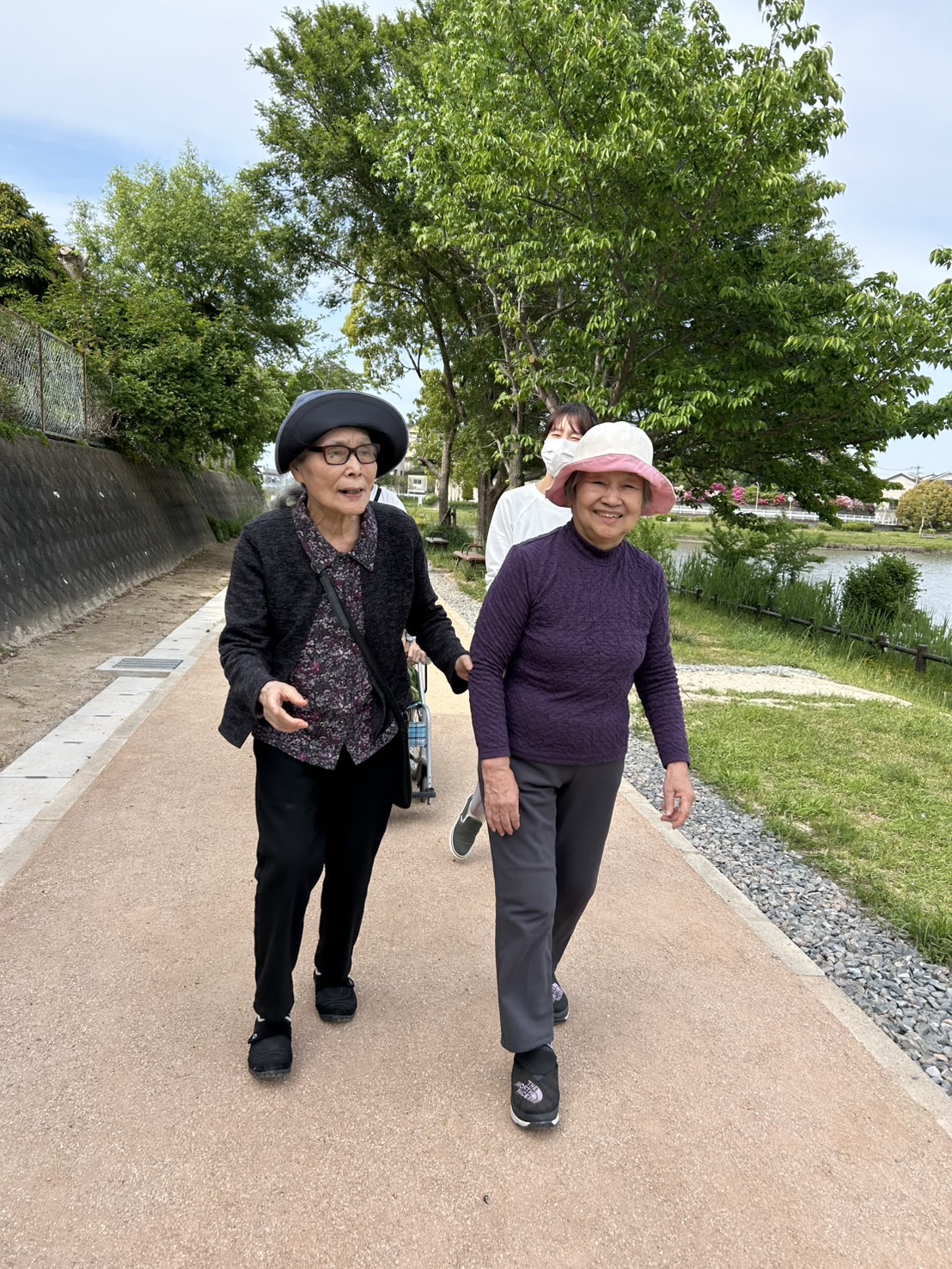 池の周りを二人並んで歩かれる利用者さんの写真
