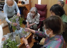 藤の花を花瓶に状背の利用者が活けられています