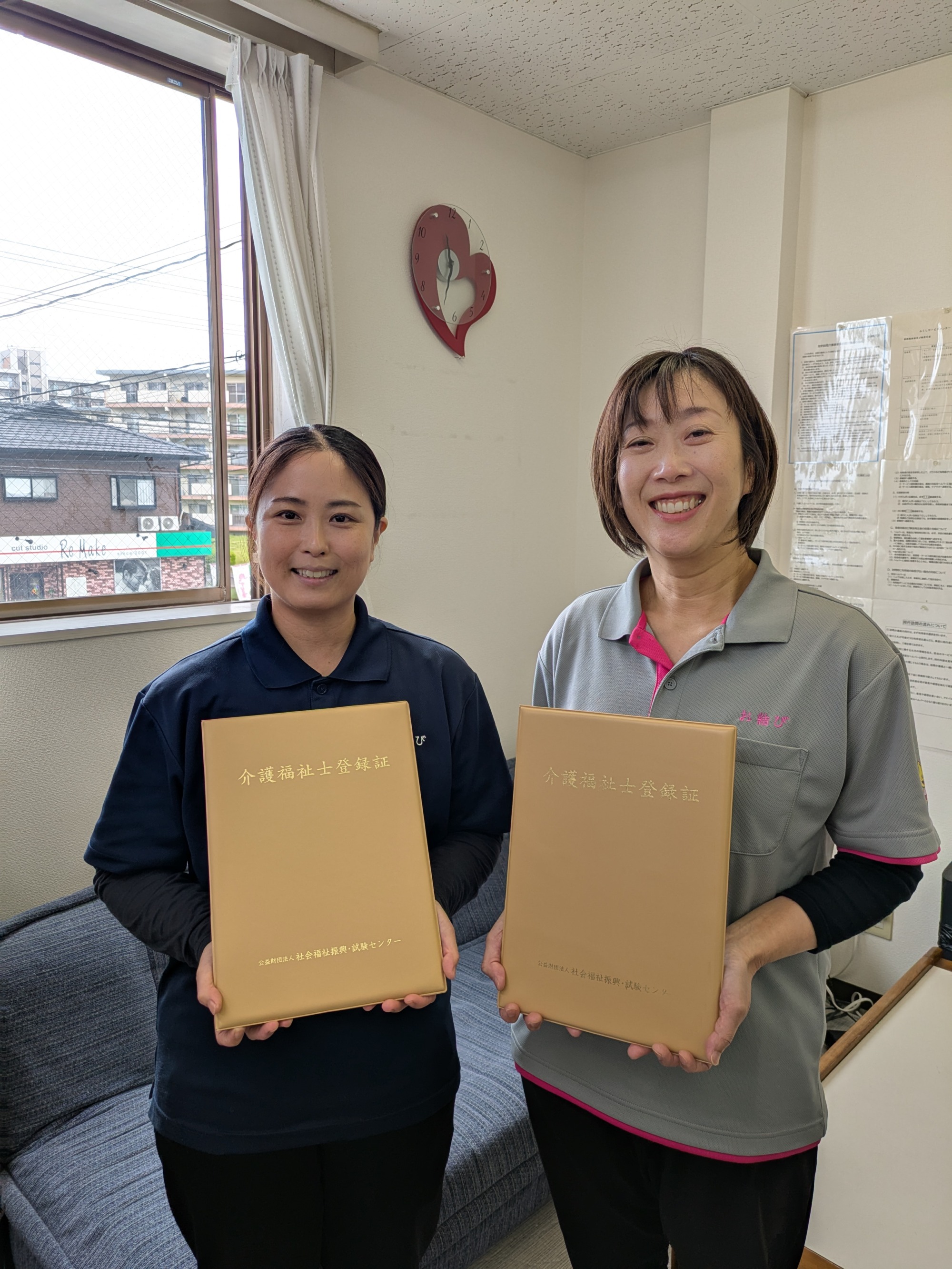 介護福祉士合格証を持って笑顔のワーカー2人