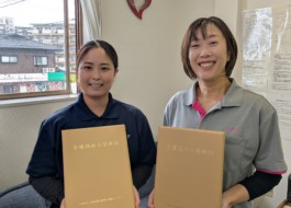介護福祉士合格証を持って笑顔のワーカー2人