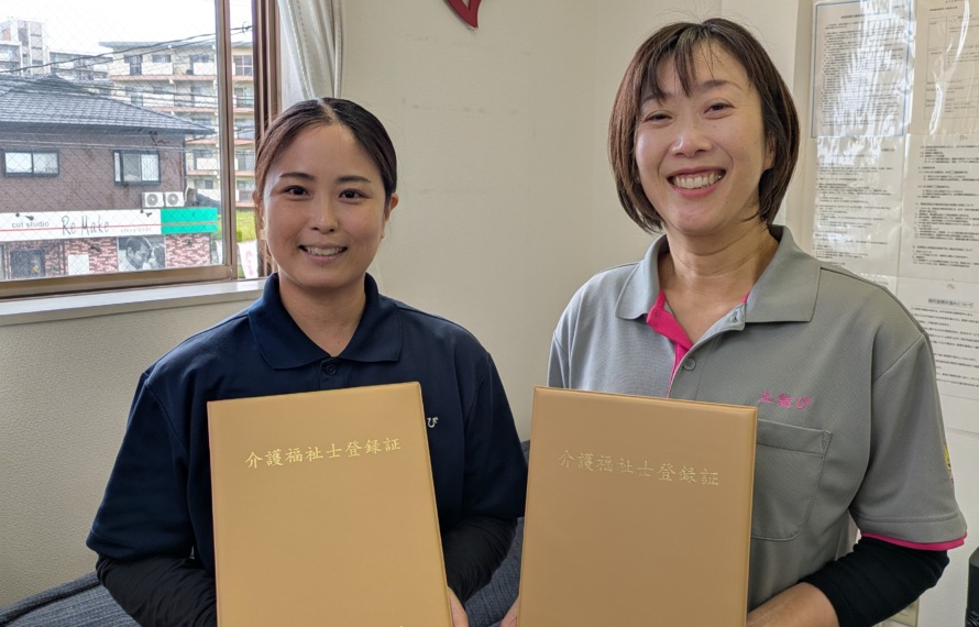 介護福祉士合格証を持って笑顔のワーカー2人