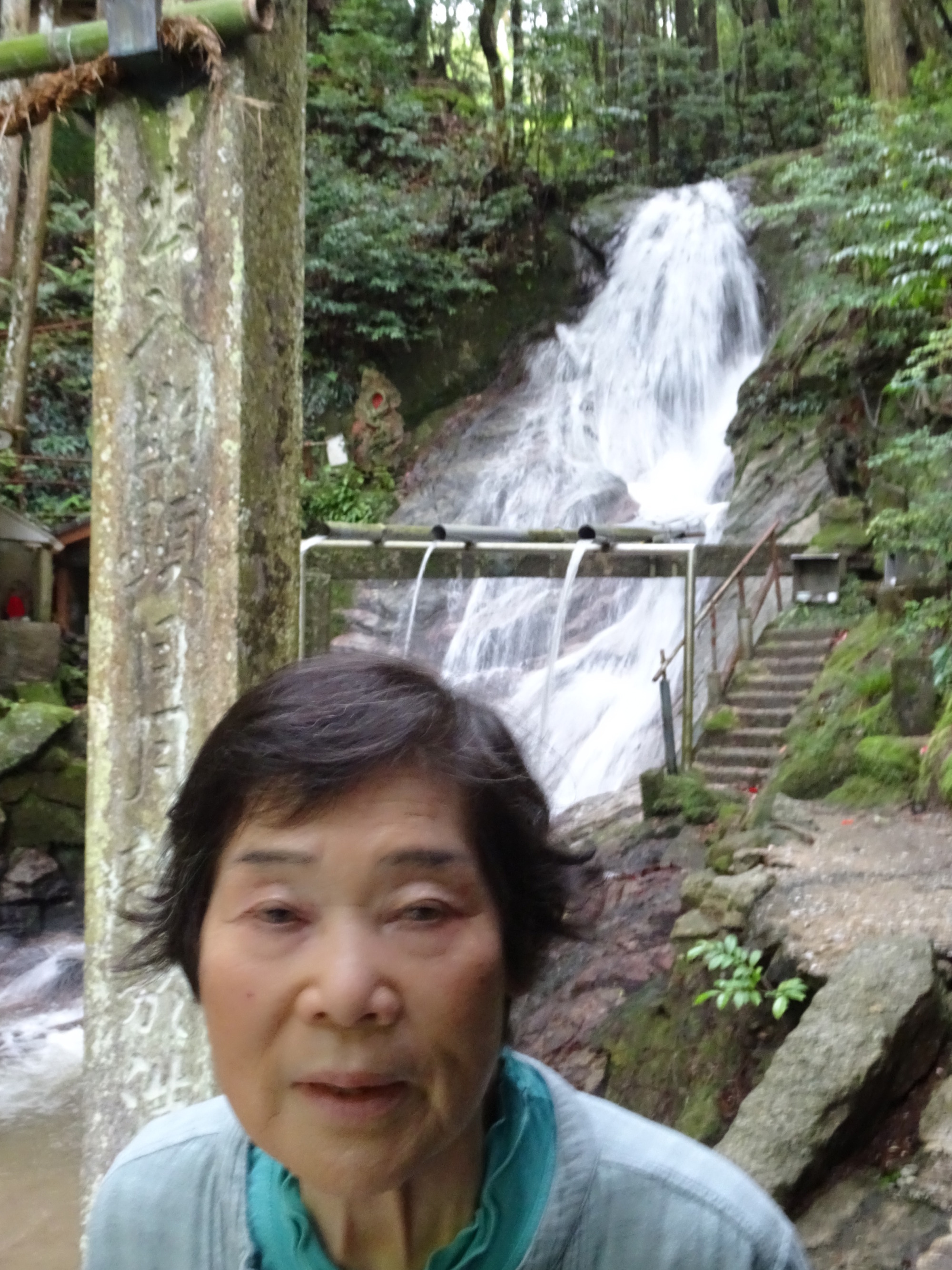 大量の水が流れる滝の前で撮った写真