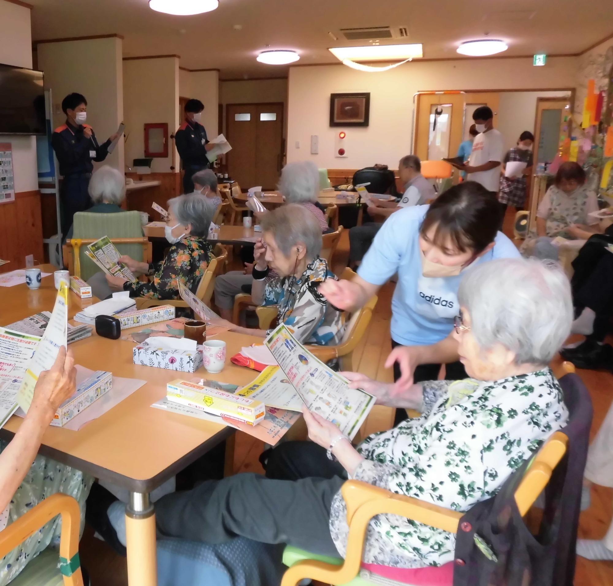 熱中症の話を聞くご利用者とスタッフ