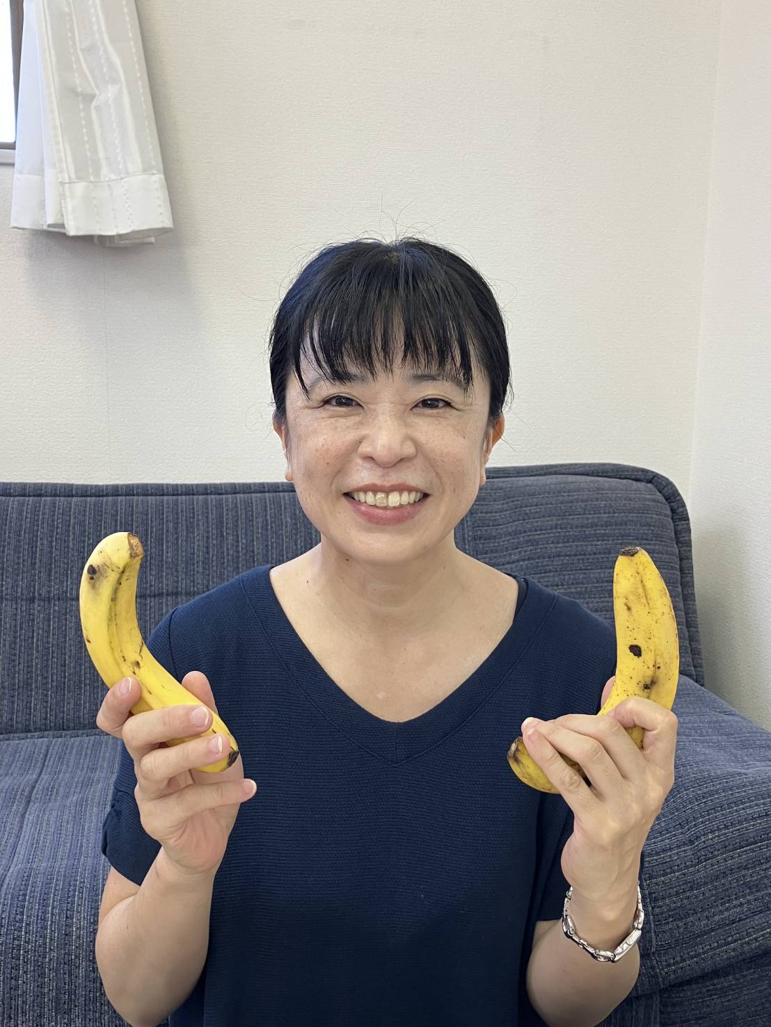 ワーカーが笑顔でバナナを2本手に持っている