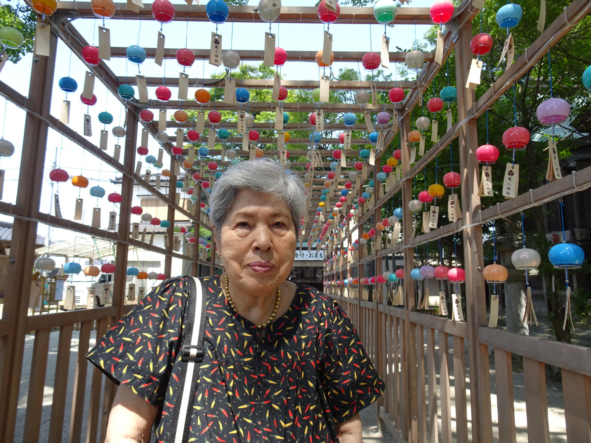現人神社の風鈴飾りの前で撮った利用者さんの写真