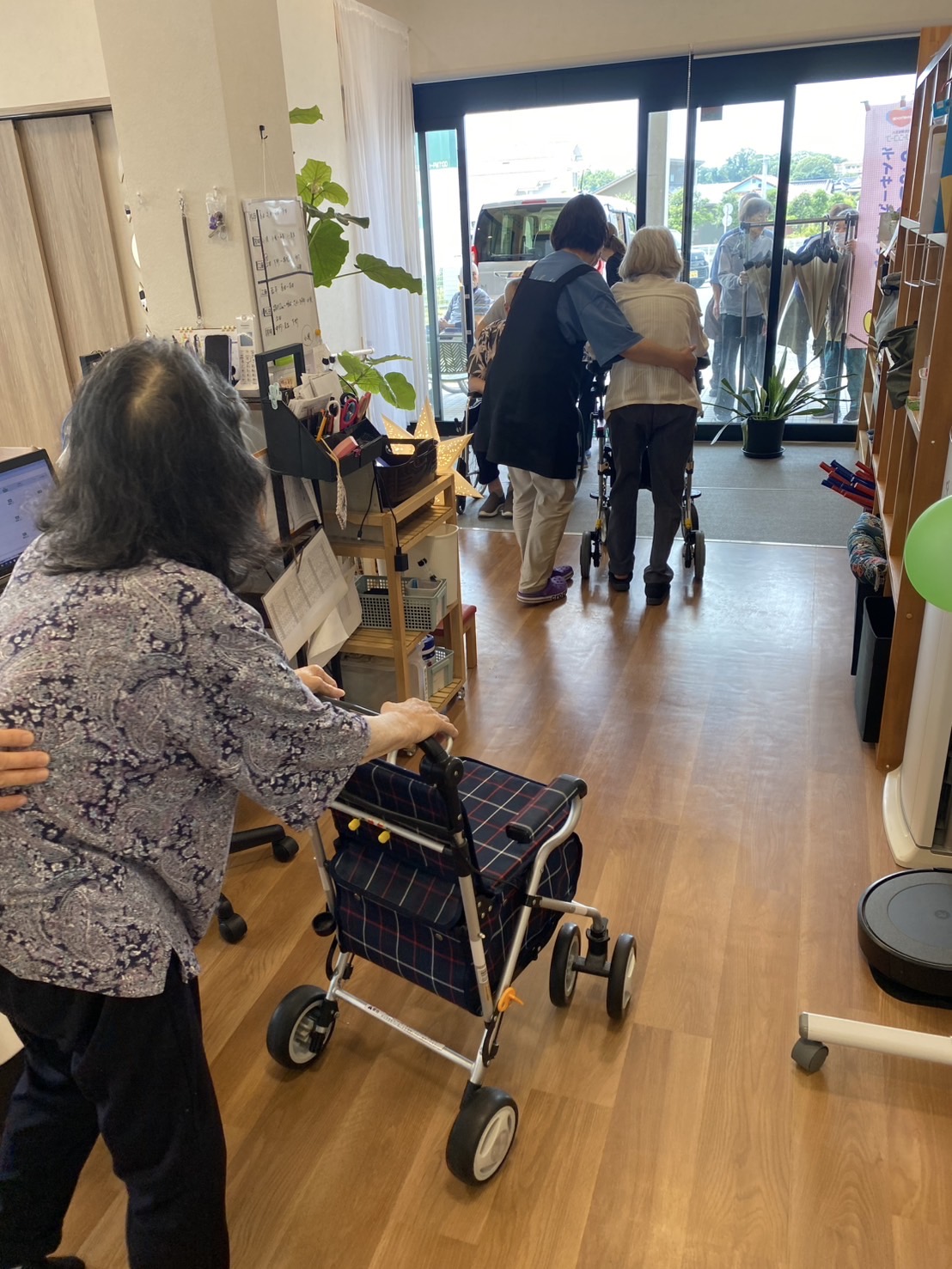 避難訓練で玄関にむかっている高齢者を支えるスタッフ