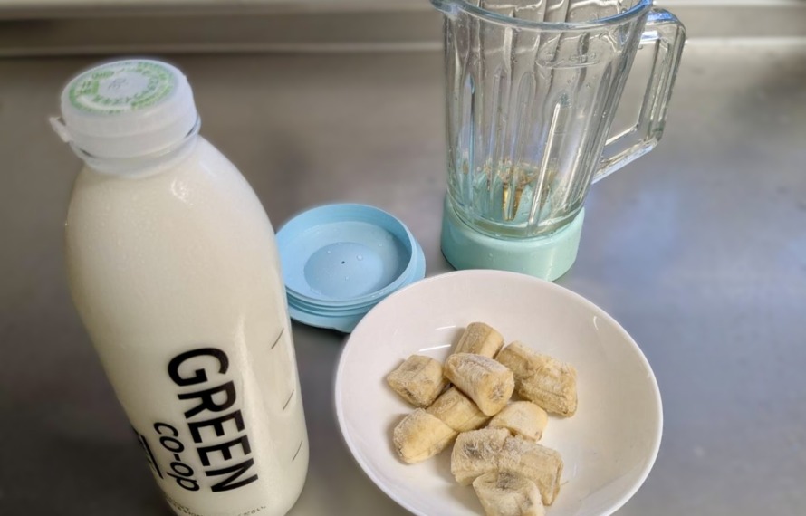 びん牛乳とカットバナナ、ミキサーの写真