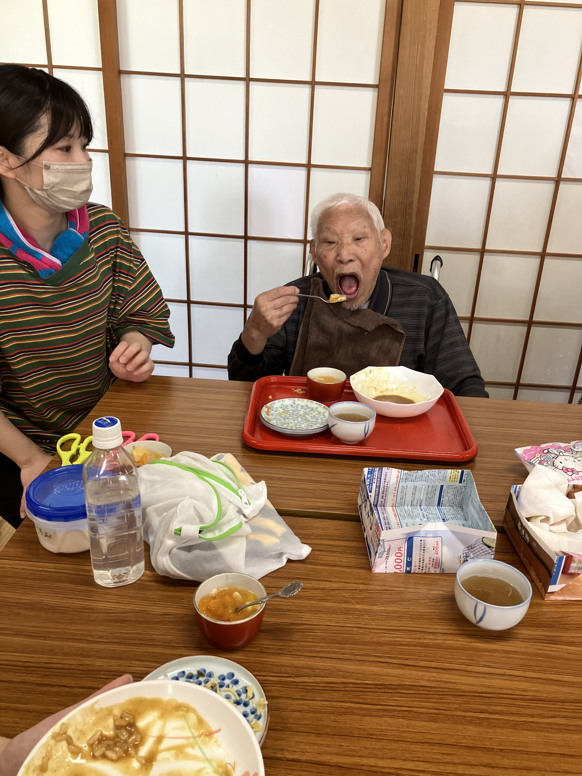 大きな口を開けて食事を召し上がる利用者さん