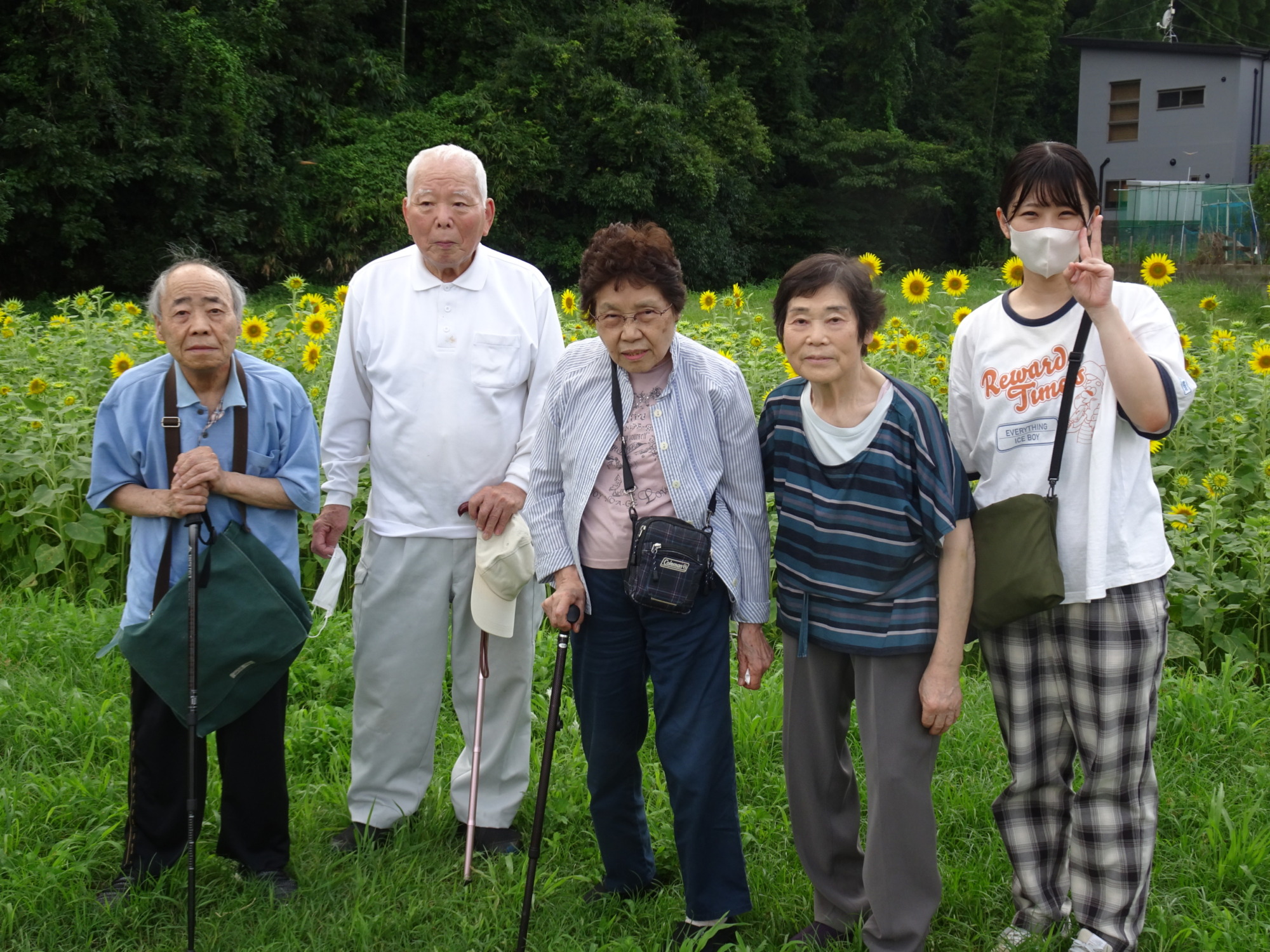 ひまわり畑の前で撮った利用者さんとワーカーの集合写真