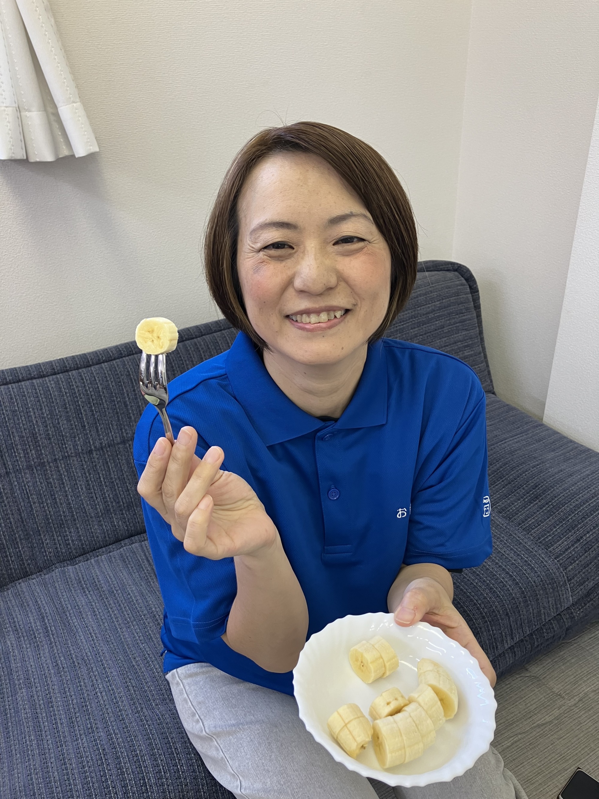 ワーカーが塩バナナを食べようとバナナをフォークにさし、笑顔で持っている