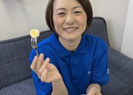 ワーカーが塩バナナを食べようとバナナをフォークにさし、笑顔で持っている