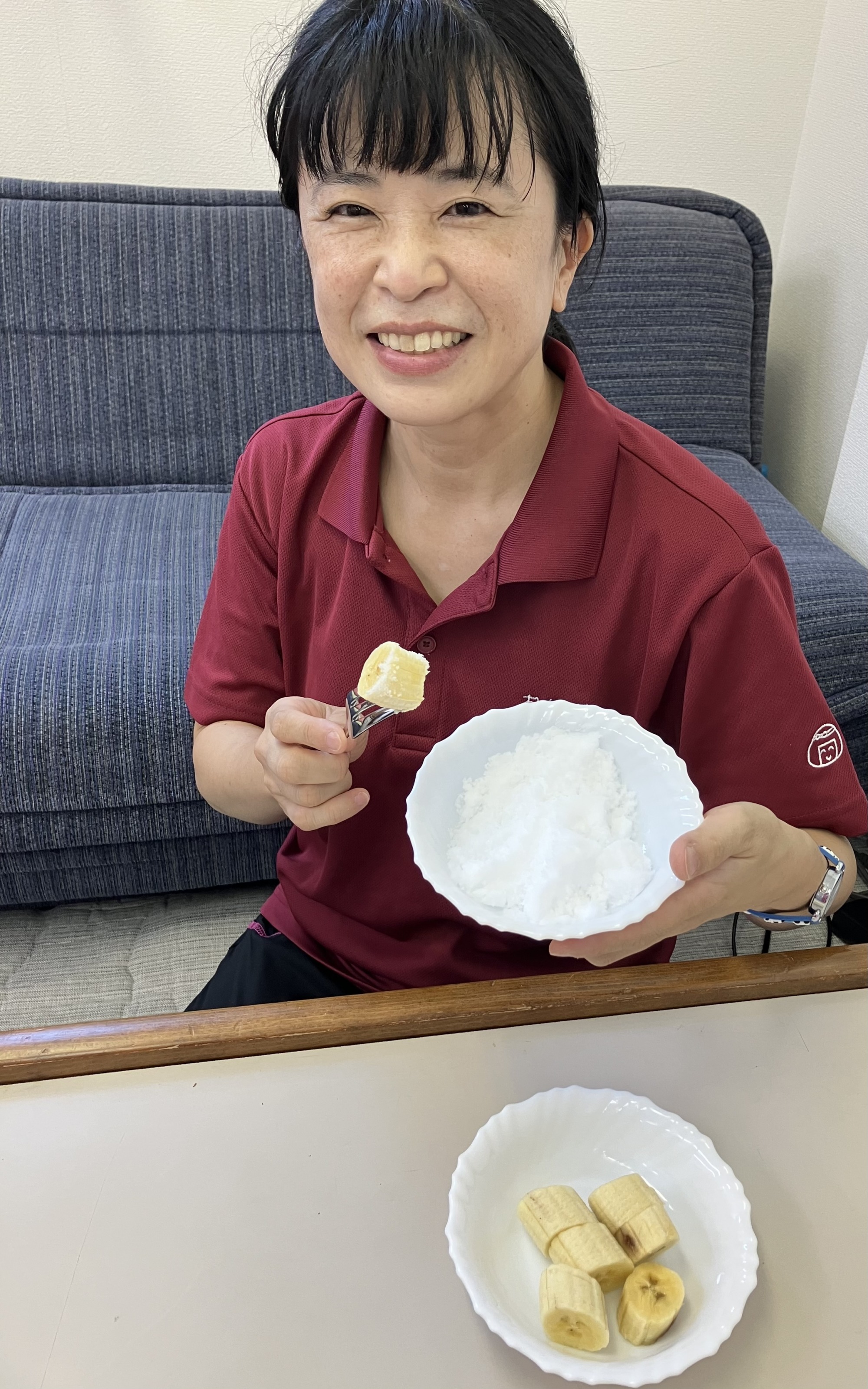 ワーカーがカットされたバナナをフォークにさし、塩をつけて食べようとしている