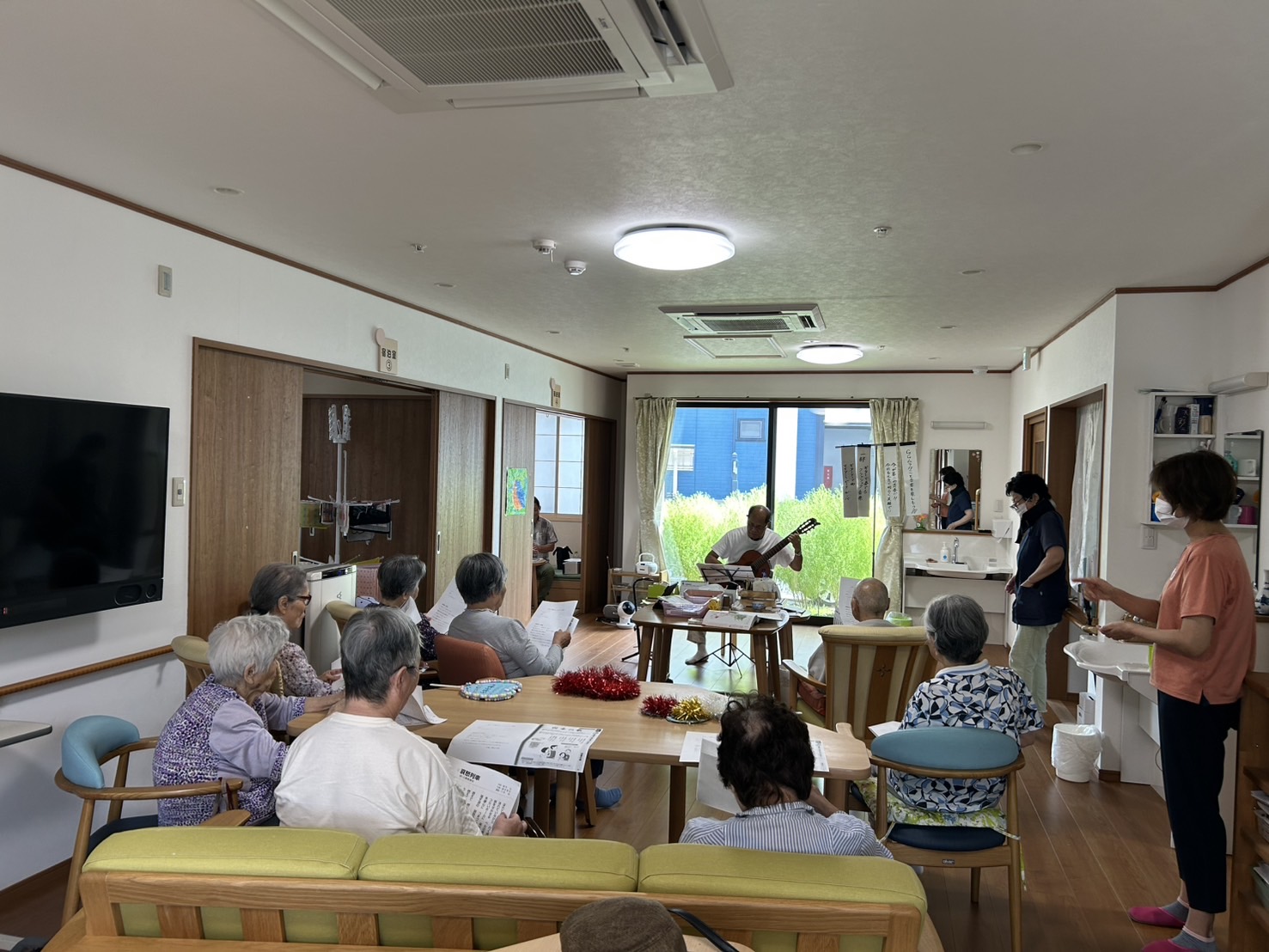 GGムラカミさんの演奏を聴く利用者さんたち