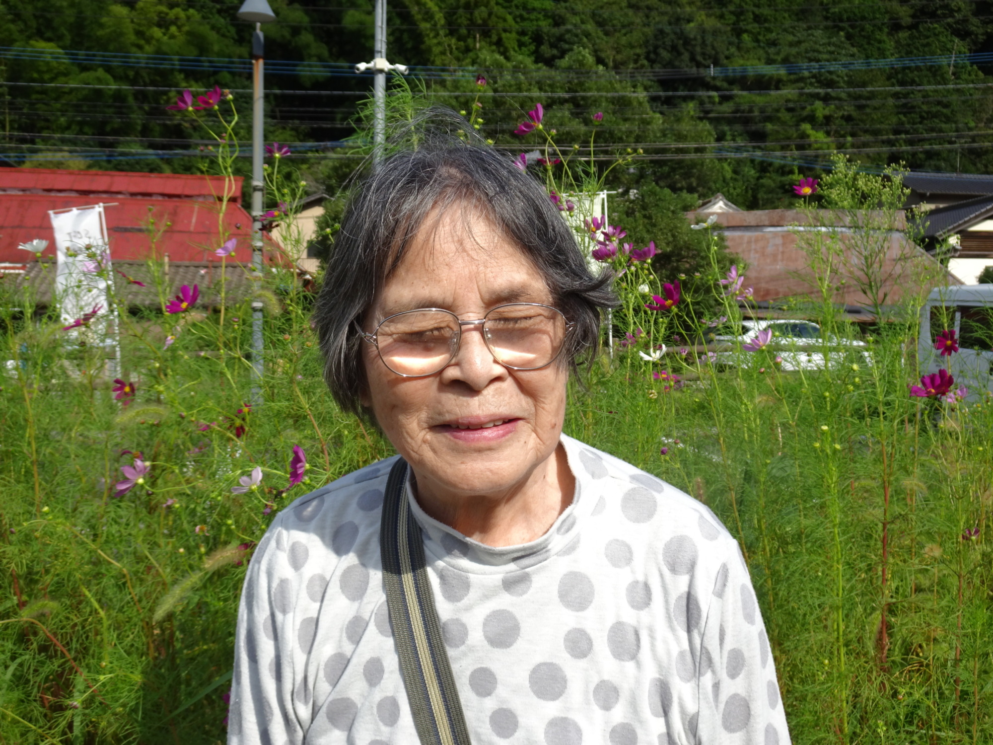 コスモスをバックに写る利用者さん