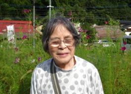 コスモスをバックに写る利用者さん
