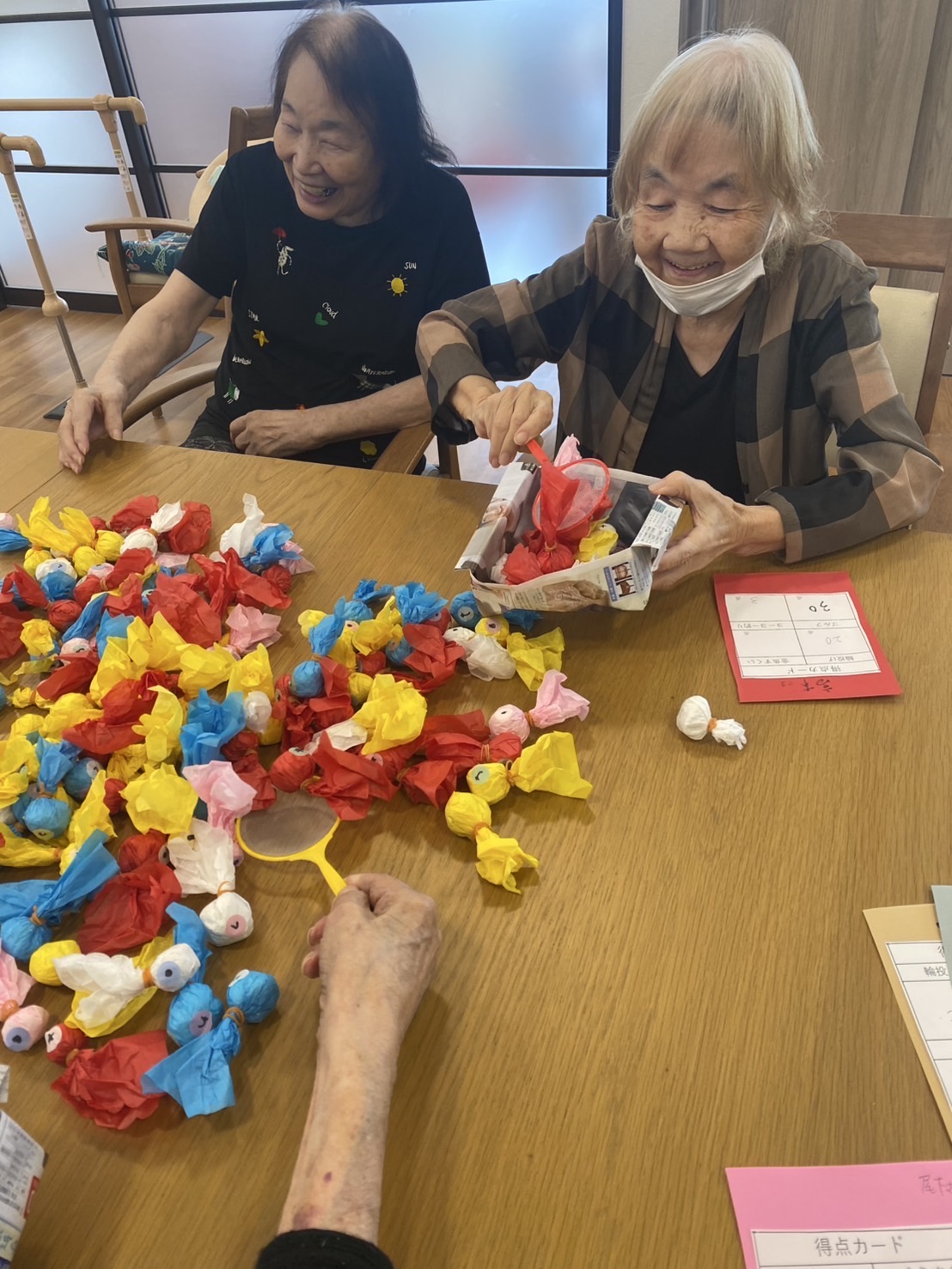 手作り金魚をすくっている高齢者女性