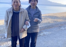 海を背景にご婦人2人がこちらを見ているようす