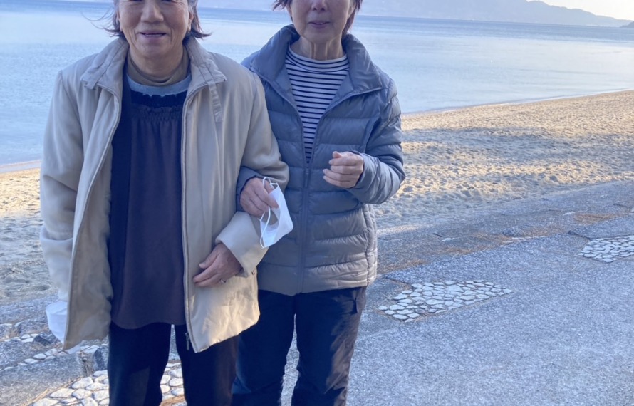 海を背景にご婦人2人がこちらを見ているようす