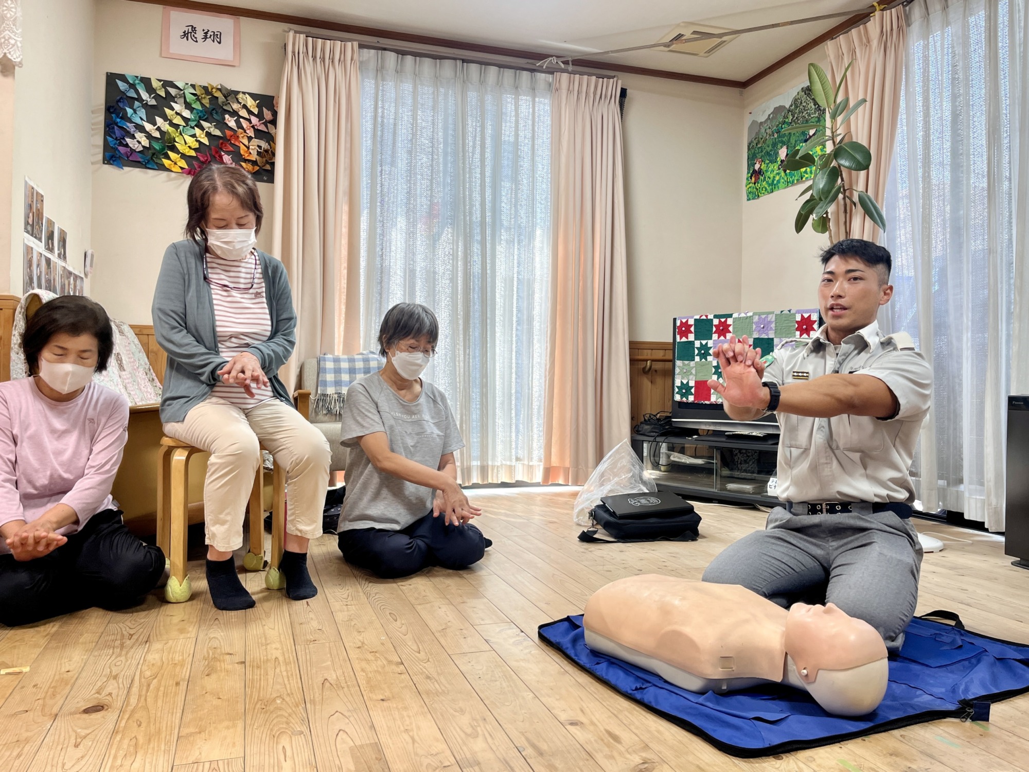 救急救命士から心臓マッサージの時の手の組み方を指導してもらっている様子