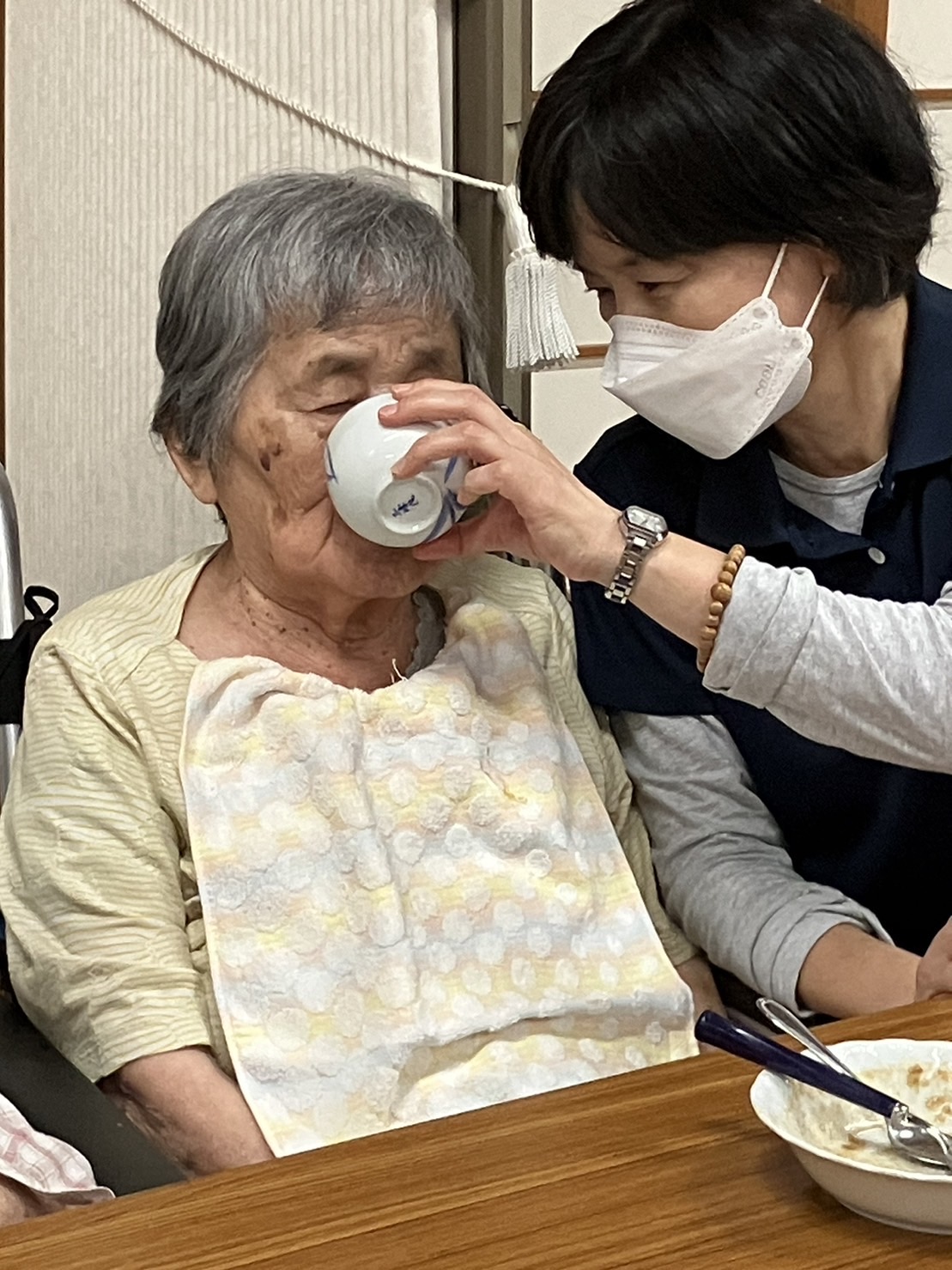 食事介助されながら食事を楽しむ利用者さん
