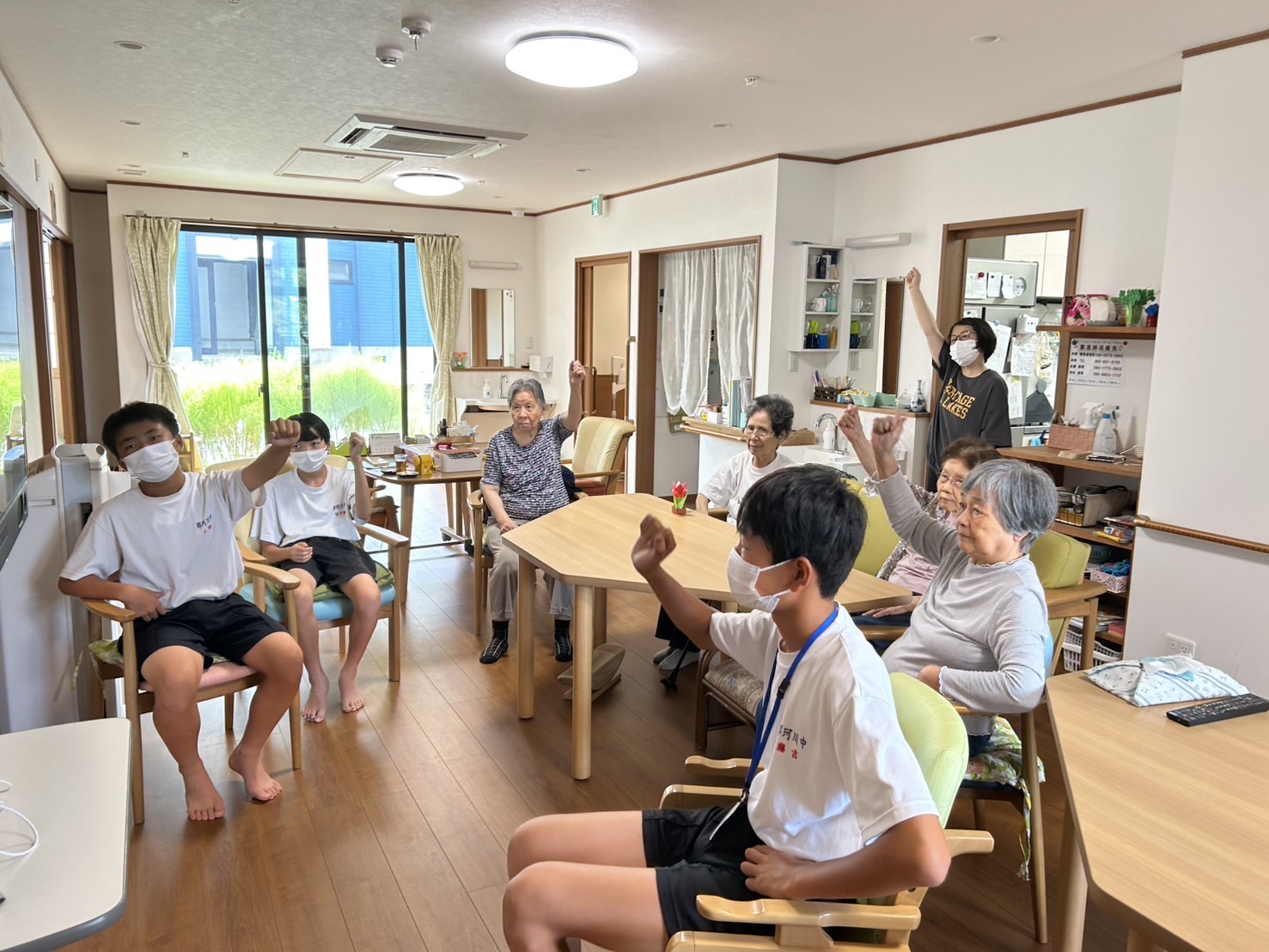 一緒に体操をする利用者さんと中学生