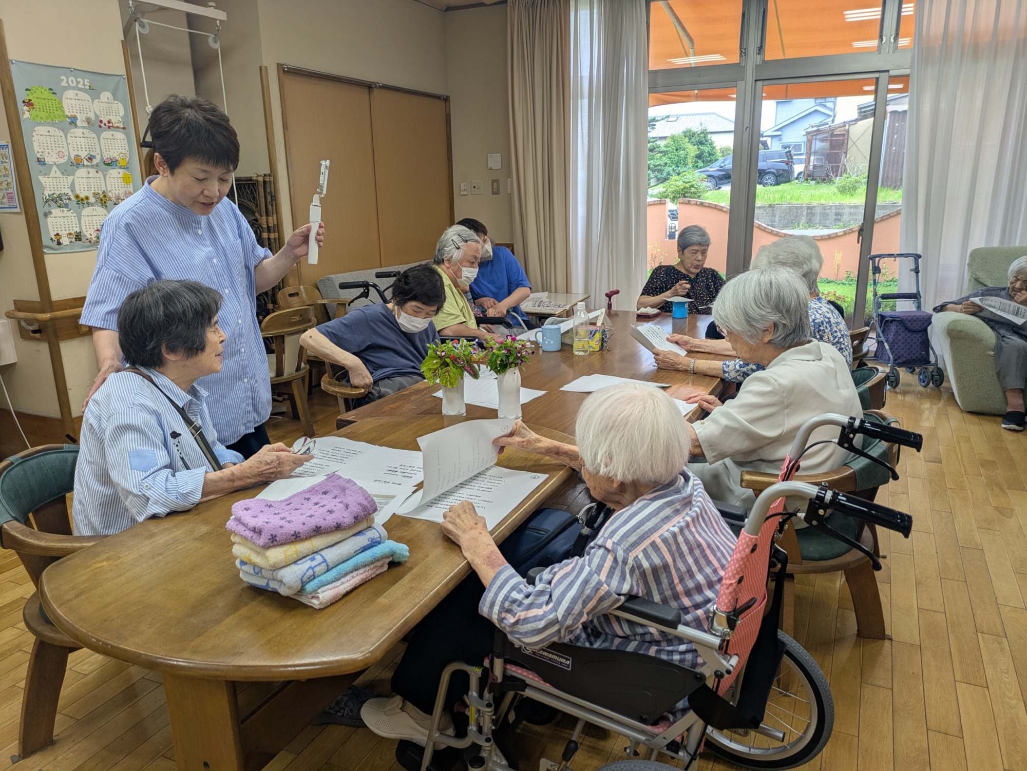 歌詞カードを見ながら歌う利用者さんたち