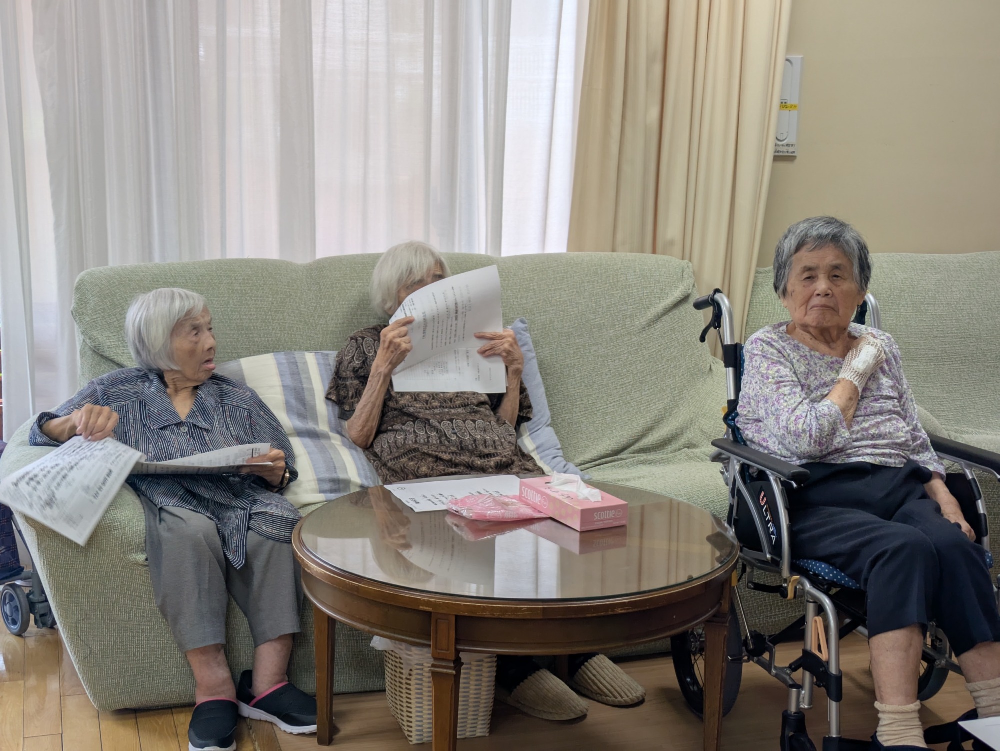 歌詞カードを見ながら歌う利用者さんたち