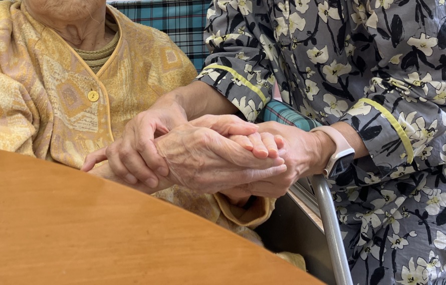 入所者さんと娘さんがしっかりと手を握っている写真