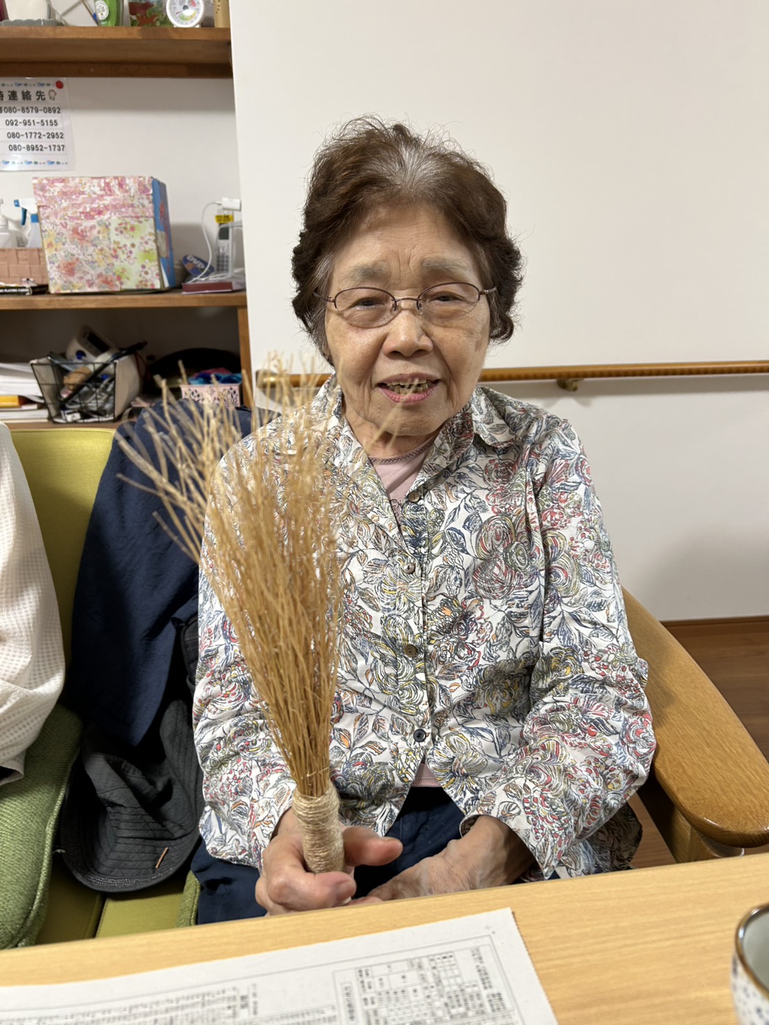 作ったホウキを手に笑顔の利用者さん