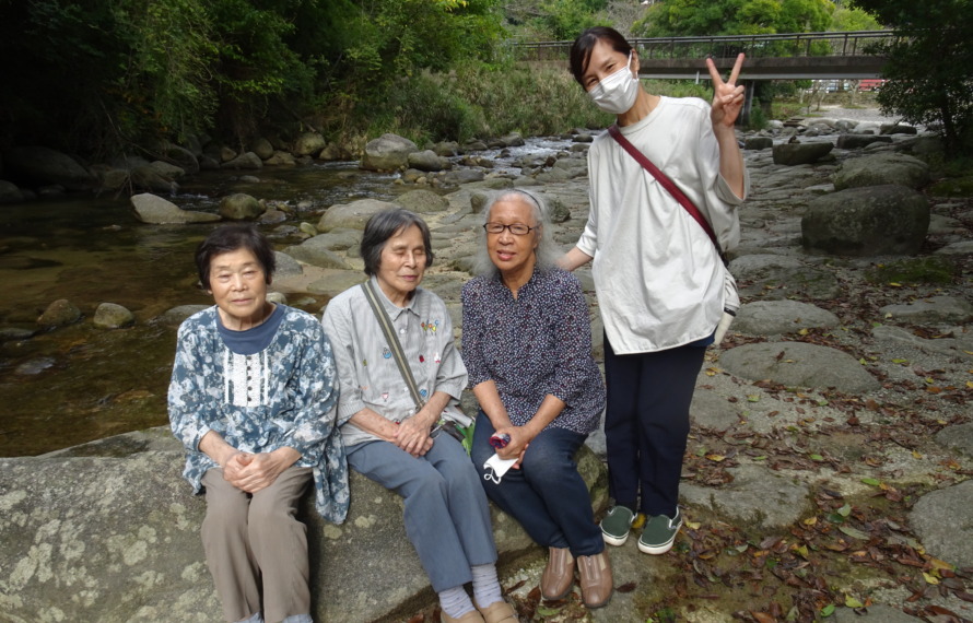 中之島公園の川の前で撮った利用者さんたちとワーカーの写真