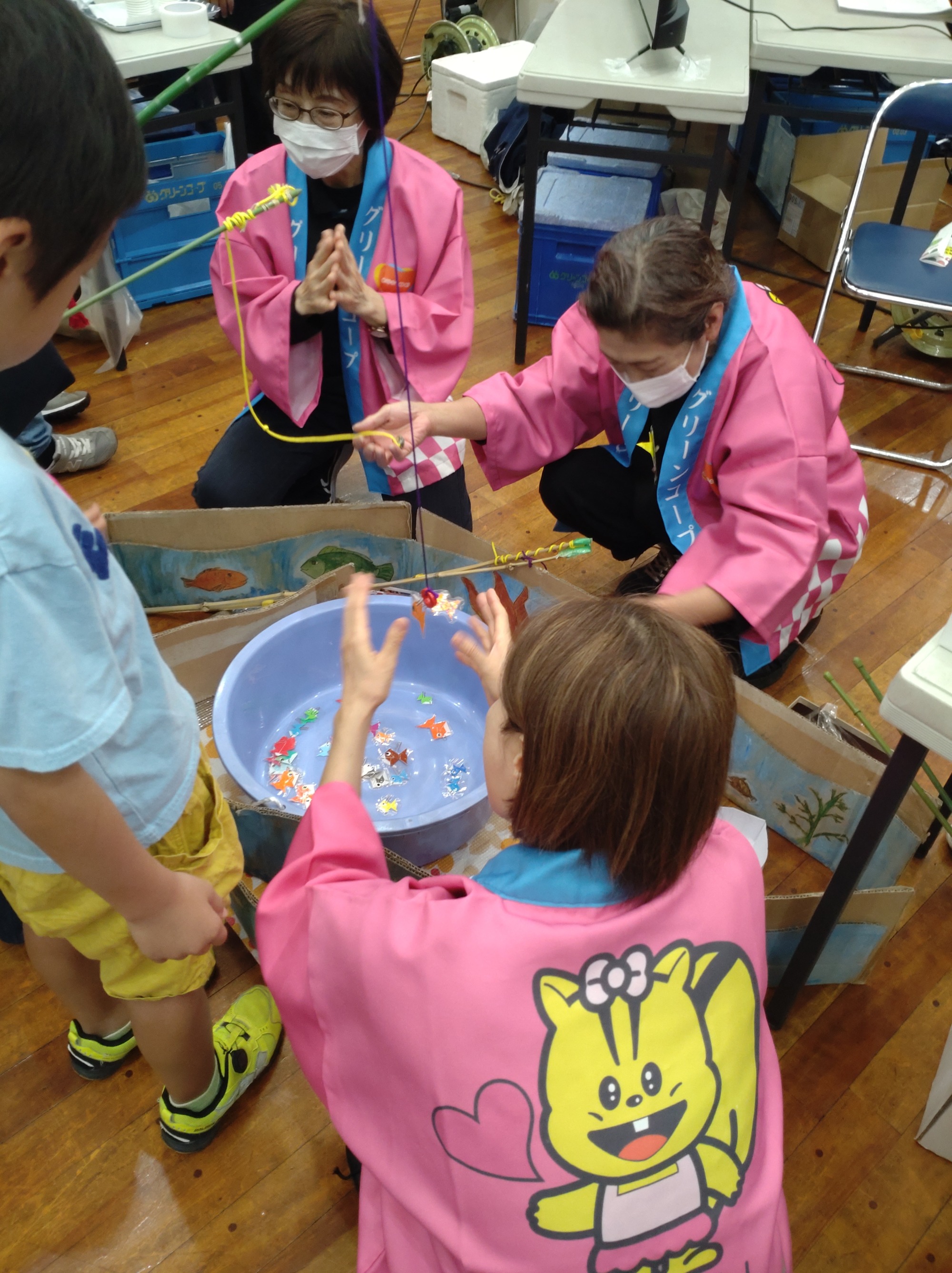 魚釣りゲームで子どもさんが魚を釣り上げ、歓声があがったところ