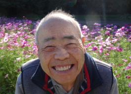 コスモス畑の前で素敵な笑顔を見せる利用者さん