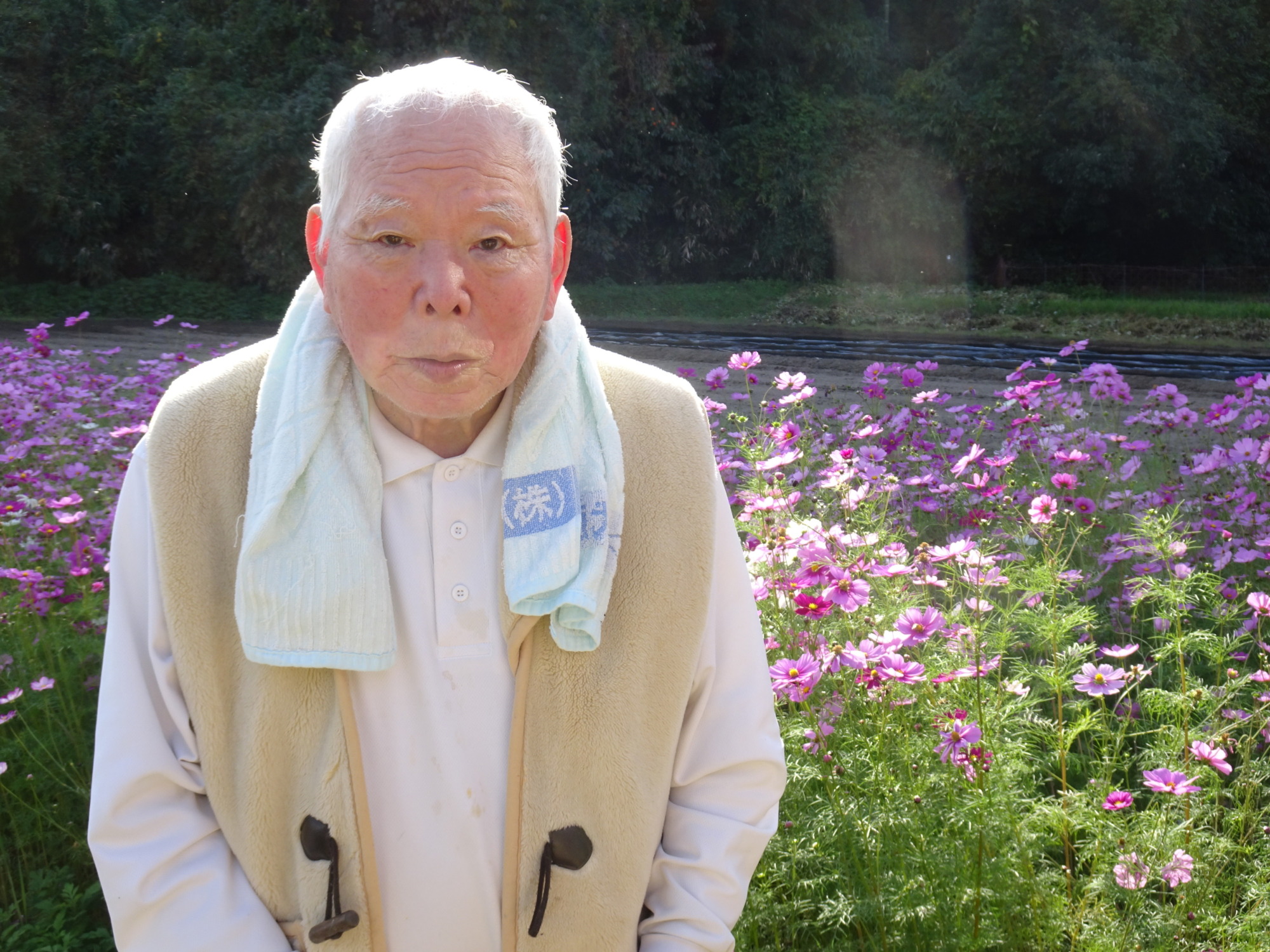 コスモス畑の前で笑顔を見せる利用者さん