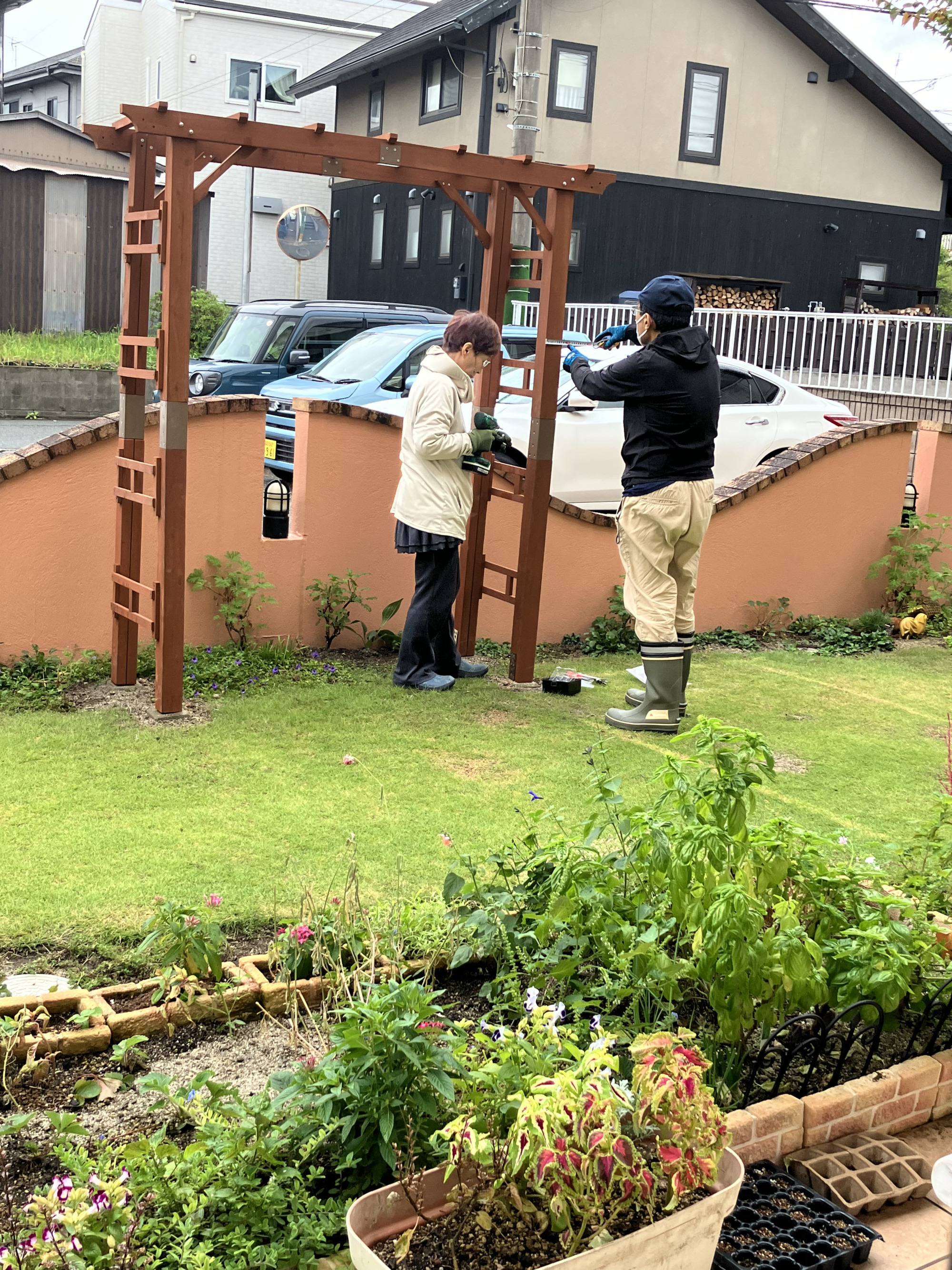 ワーカーが夫婦でパーゴラを組み立てている様子