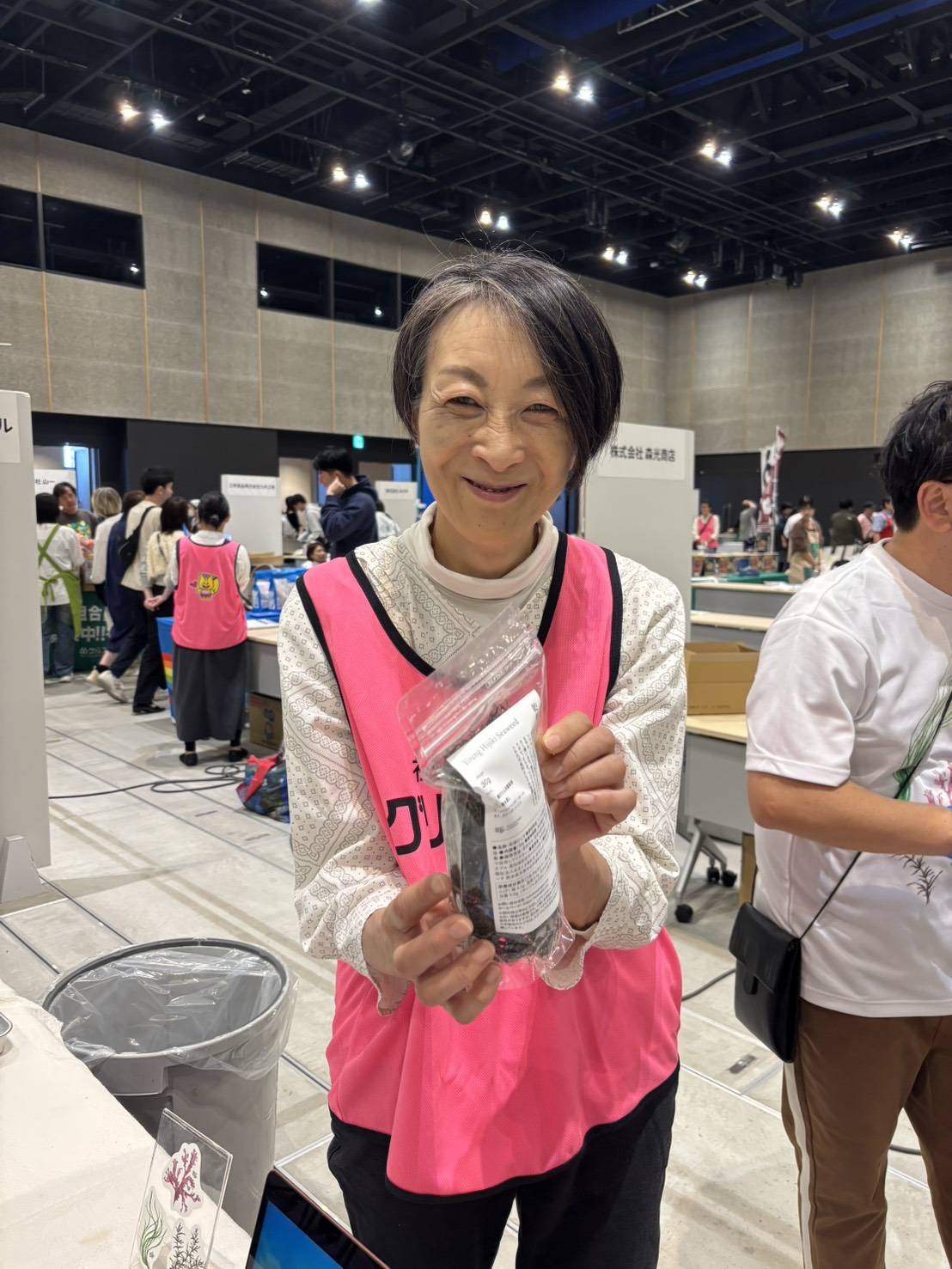 ワーカーがシーフードベジタブルを持って笑顔で販売している