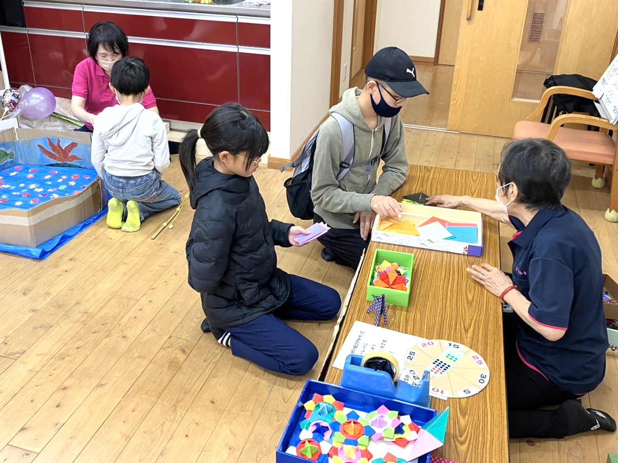折り紙の折り方を聞く子ども達