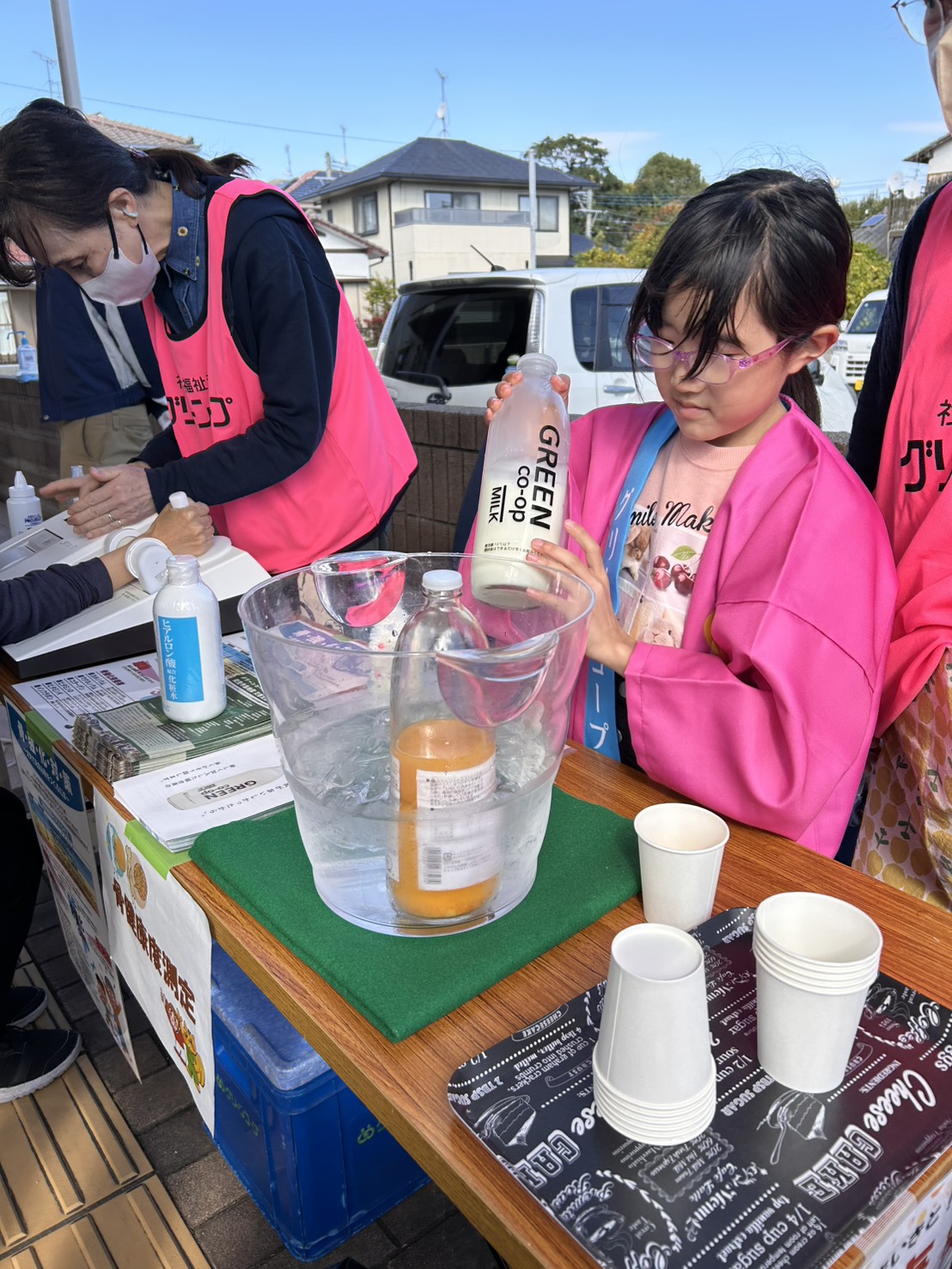 牛乳の試飲のお手伝いをするワーカーのお子さん