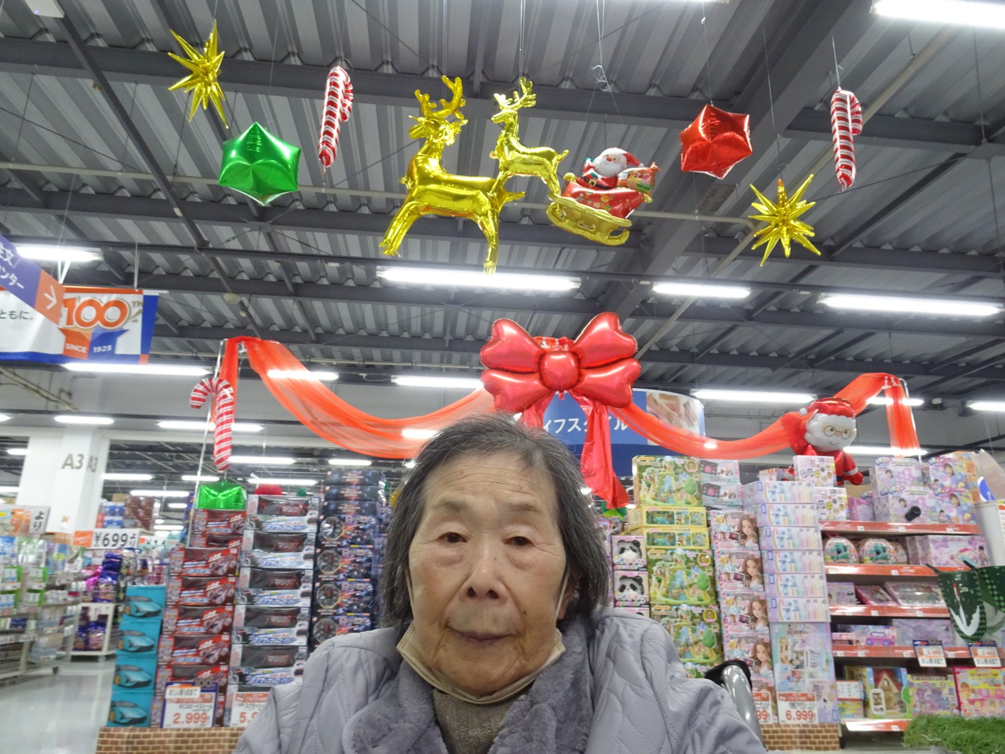 店内のクリスマス装飾と一緒に写る利用者さん