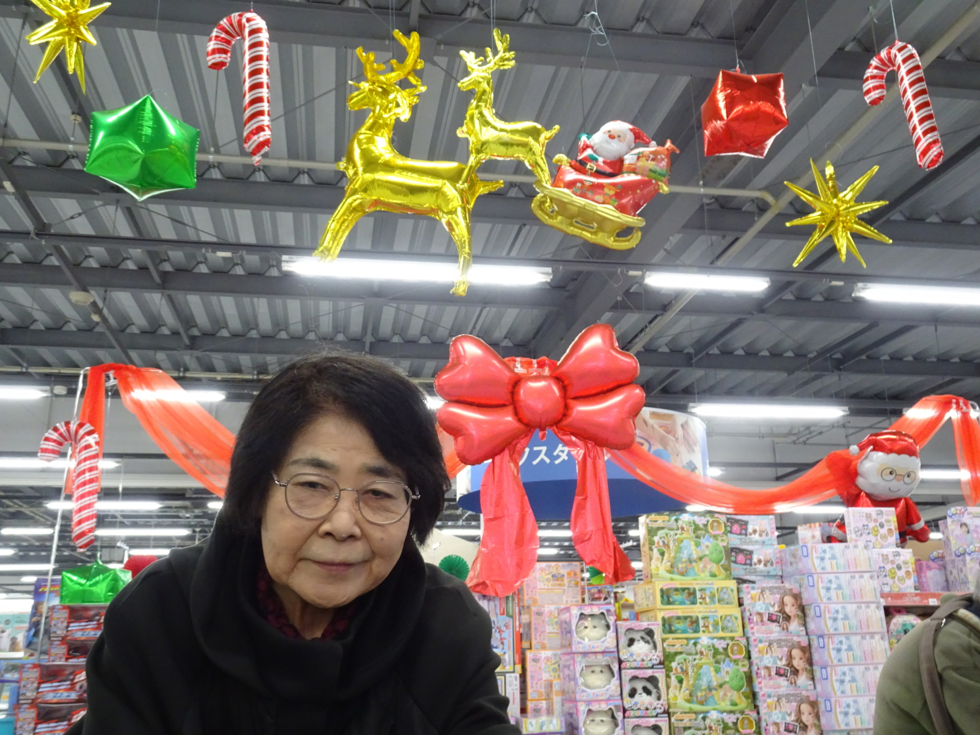 店内のクリスマス装飾と一緒に写る利用者さん
