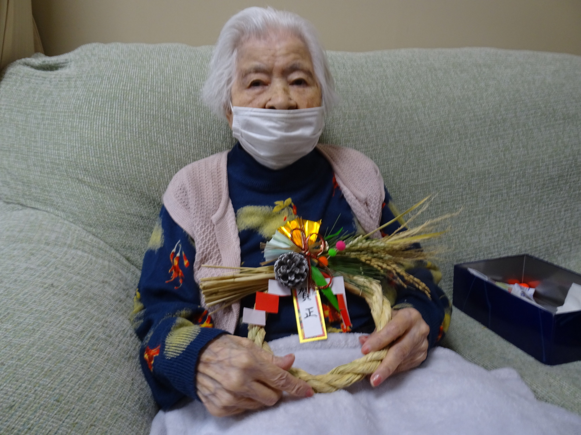 完成したしめ縄を持って写る利用者さん