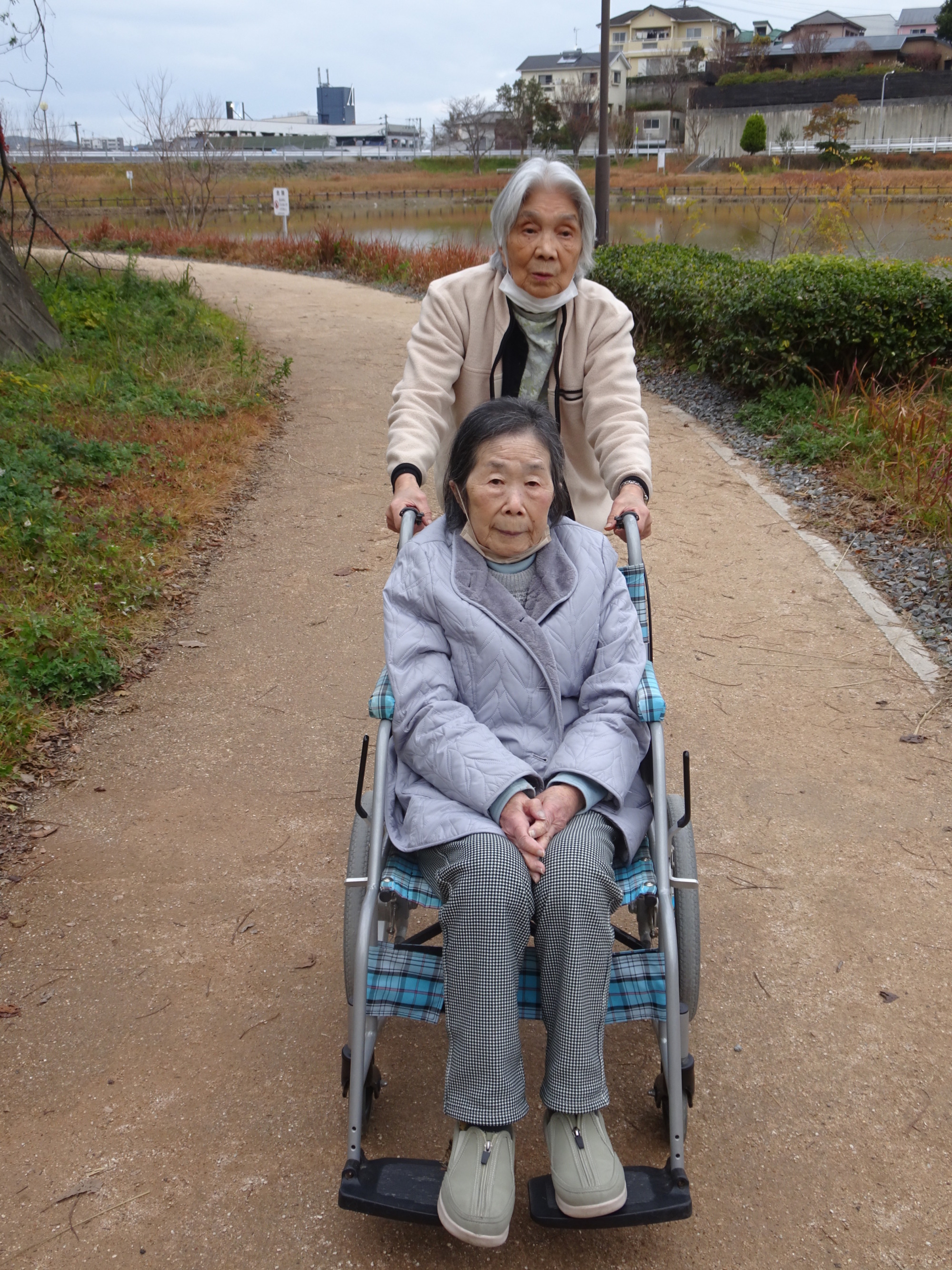 利用者さんの車椅子を押してあげる他の利用者さん