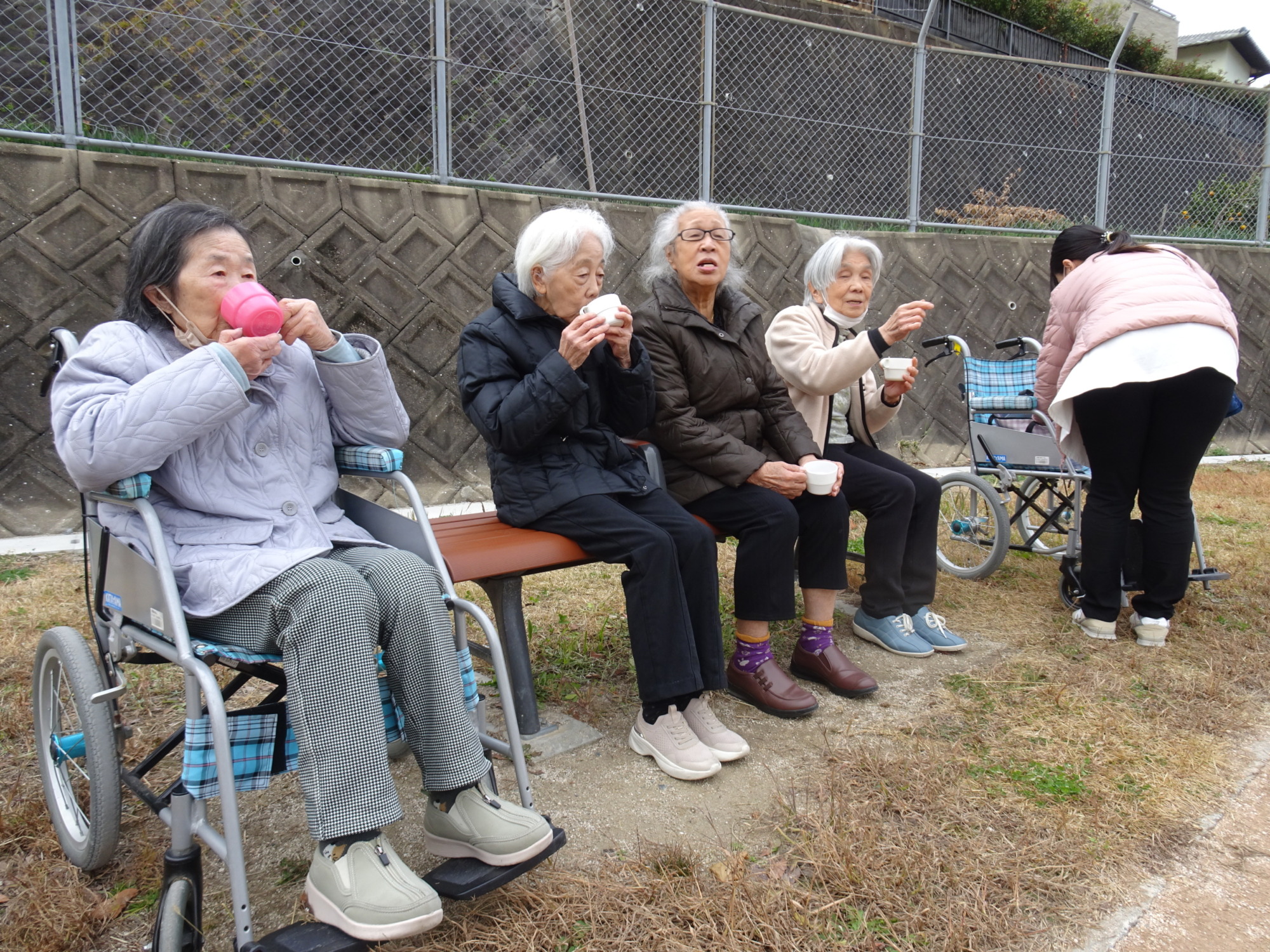 ベンチでお茶を飲む利用者さんたち