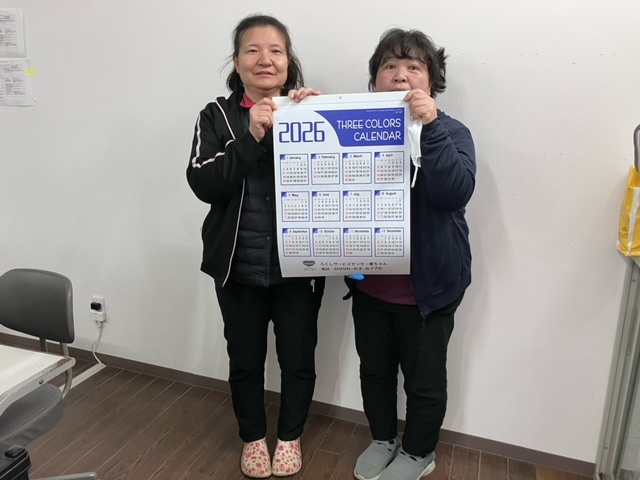 女性2名がカレンダーを持っている