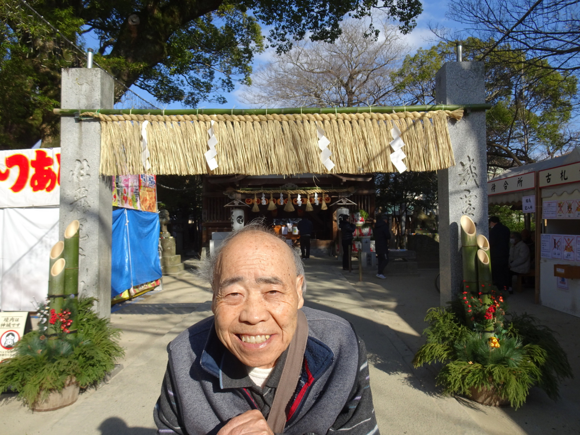 現人神社の鳥居の前で写真にうつる利用者さん