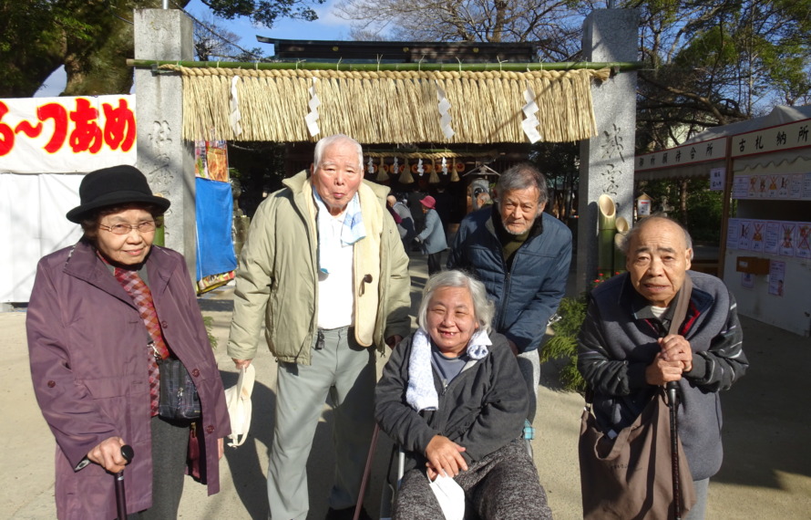 現人神社の鳥居の前で写真にうつる利用者さんたち