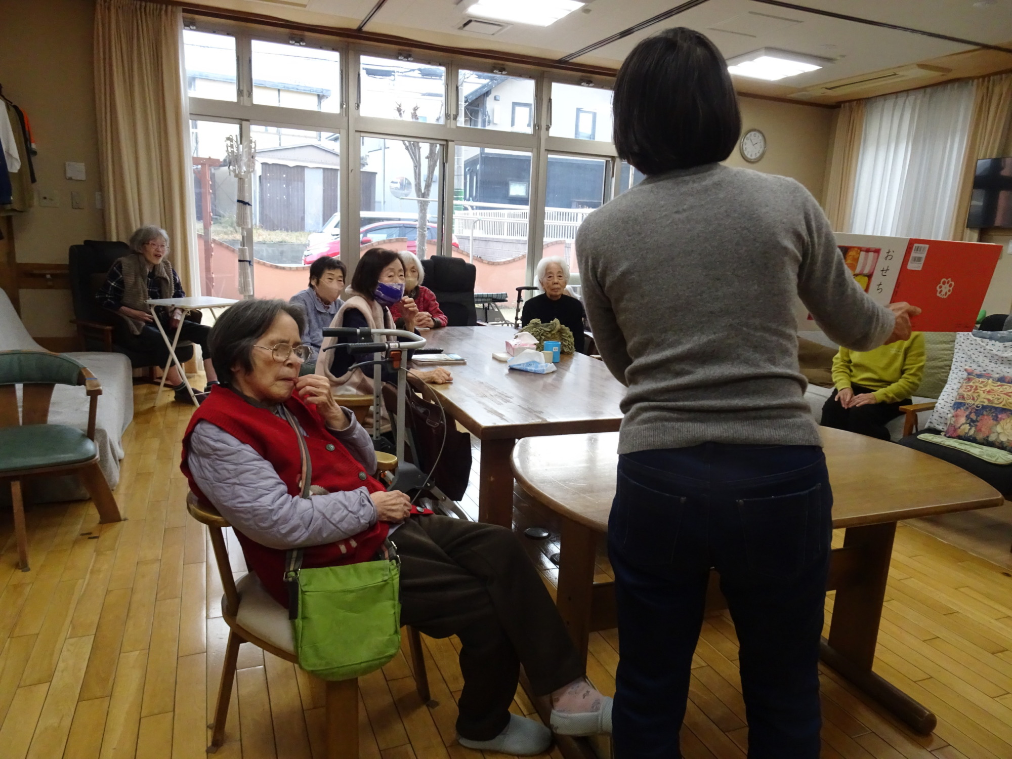 絵本を読み聞かせるボランティアの方とそれを聴く利用者さんたち